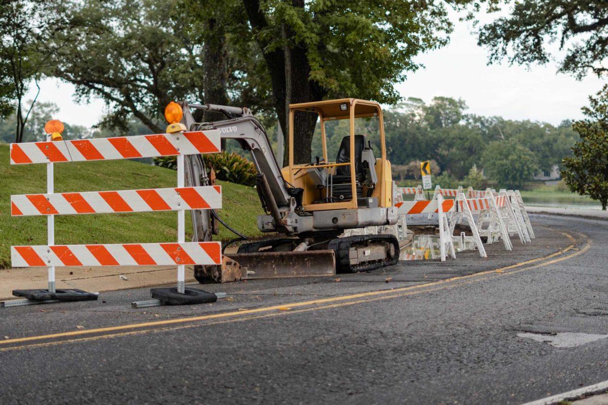 An excavator seats near barriers on Tuesday, Sept. 26, 2023, on West Lakeshore Drive in Baton Rouge, La.