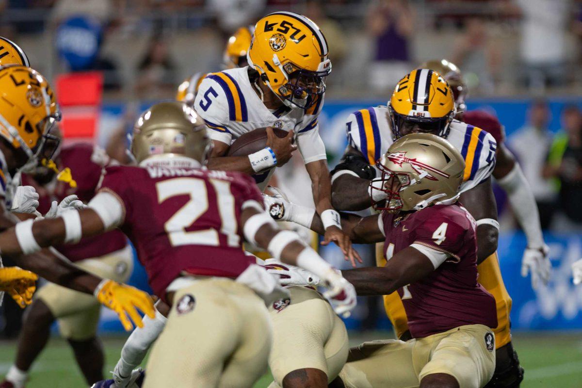 LSU football senior quarterback Jayden Daniels (5) attempts to run through Florida State&#8217;s defense on Sunday, Sept. 3, 2023, during LSU&#8217;s 45-24 loss to Florida State at Camping World Stadium in Orlando, Fl.