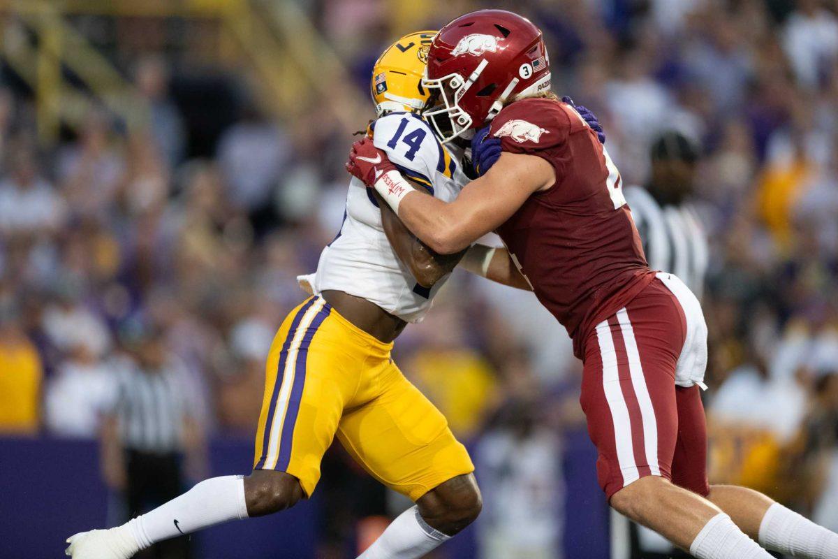 LSU football senior safety Andre' Sam (14) pushes against his opponent Saturday, Sept. 23, 2023, during LSU's&#160;34-31 win&#160;against Arkansas at Tiger Stadium in Baton Rouge, La.