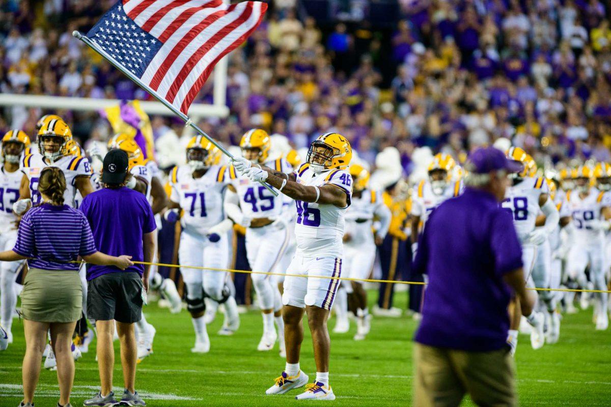 LSU football redshirt junior linebacker Shelby Lee Jr. (46) swings an American flag on Saturday, Oct. 21, 2023, during LSU's 62-0 victory against Army in Tiger Stadium in Baton Rouge, La.