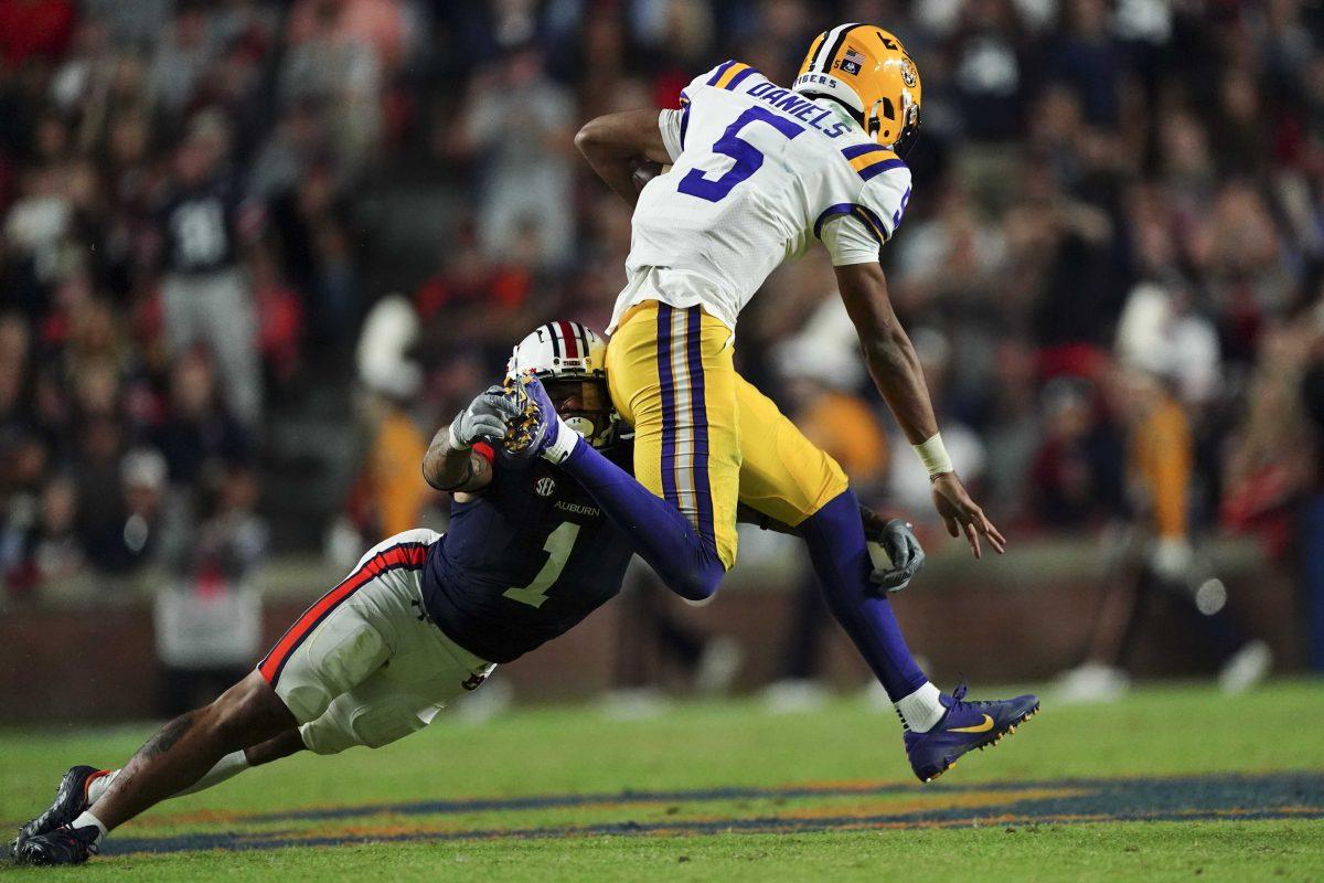 LSU quarterback Jayden Daniels (5) breaks away from Auburn safety Donovan Kaufman (1) in the first half of an NCAA college football game, Saturday, Oct. 1, 2022, in Auburn, Ala. (AP Photo/John Bazemore)