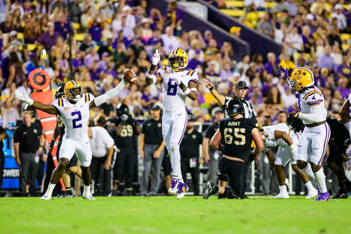 LSU football senior defensive end Ovie Oghoufo (2), LSU football junior safety Major Burns (8), and LSU football sophomore linebacker Harold Perkins Jr. (4) celebrate a fumble on Saturday, Oct. 21, 2023, during LSU's 62-0 victory against Army in Tiger Stadium in Baton Rouge, La.