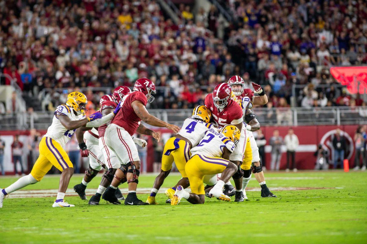 LSU football sophomore linebacker Harold Perkins Jr. (4) and LSU football senior jack Ovie Oghoufo (2) tackle an Alabama football player on Saturday, Nov. 4, 2023, during LSU's 42-28 loss against Alabama in Bryant-Denny stadium in Tuscaloosa, Al.