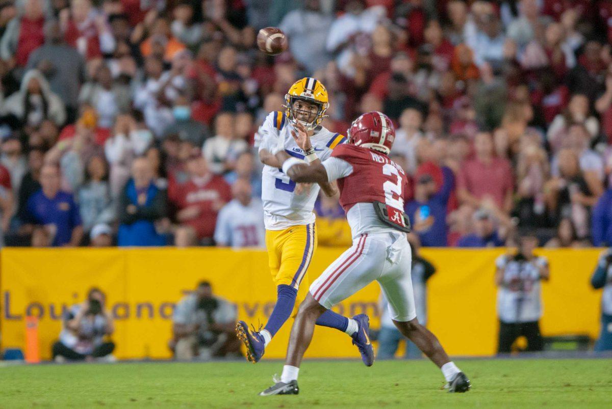 <p>LSU football junior quarterback Jayden Daniels (5) throws the ball over his opponent on Saturday, Nov. 5, 2022, during LSU’s 32-31 victory over Alabama in Tiger Stadium in Baton Rouge, La.</p>