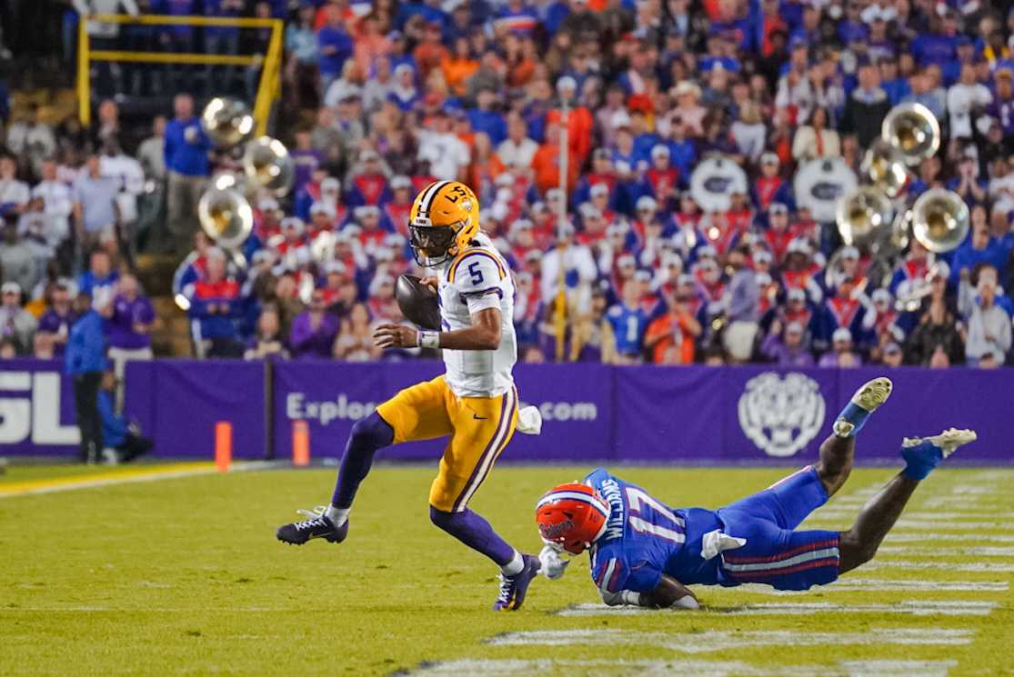 LSU football senior quarterback Jayden Daniels (5) avoids a defender Saturday, Nov. 11, 2023, during LSU&#8217;s 52-35 win against Florida in Tiger Stadium in Baton Rouge, La.