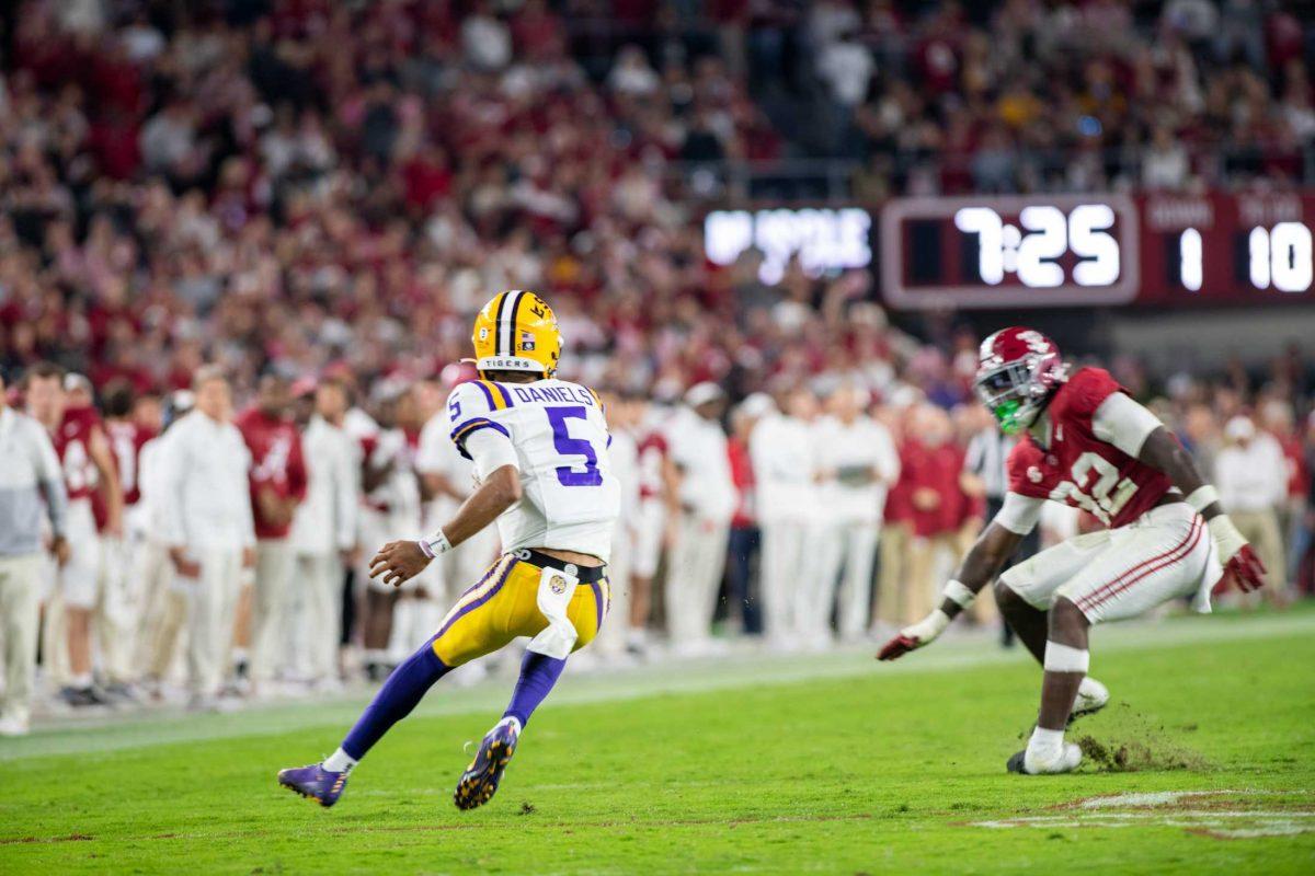 LSU football senior quarterback Jayden Daniels (5) dodges an Alabama football player on Saturday, Nov. 4, 2023, during LSU's 42-28 loss against Alabama in Bryant-Denny stadium in Tuscaloosa, Al.