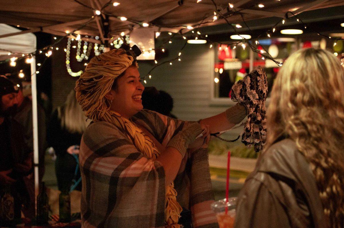 A merchant smiles and engages with customers on Friday, Nov. 18, 2022, at Mid City Merchant's White Light Night on Government Street in Baton Rouge, La.