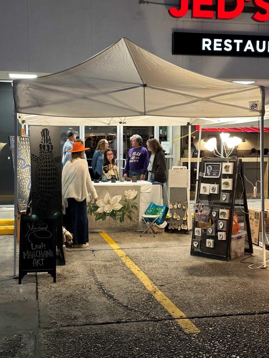 Visitors stand at a booth in front of Jed's Restaurant for White Light Night on Friday, Nov. 17, 2023.