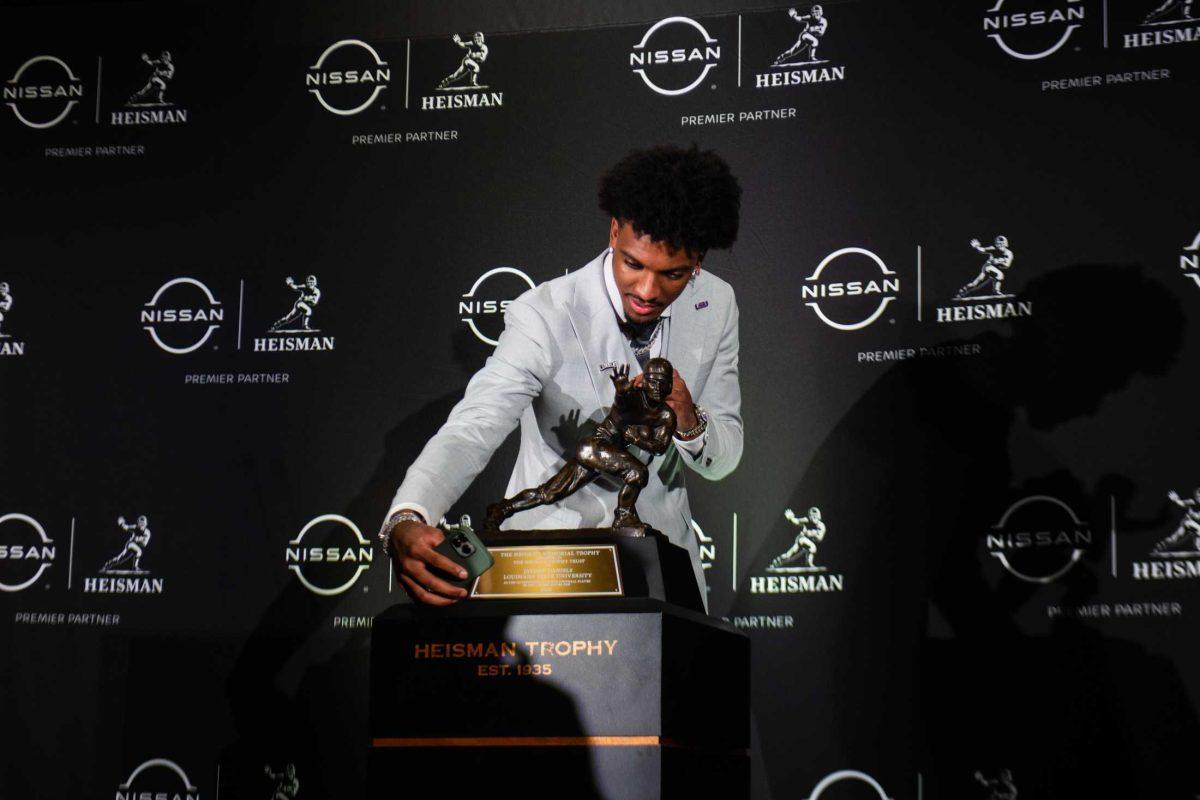 LSU senior quarterback and Heisman winner Jayden Daniels takes a picture with the Heisman trophy on Saturday, Dec. 9, 2023, in New York.