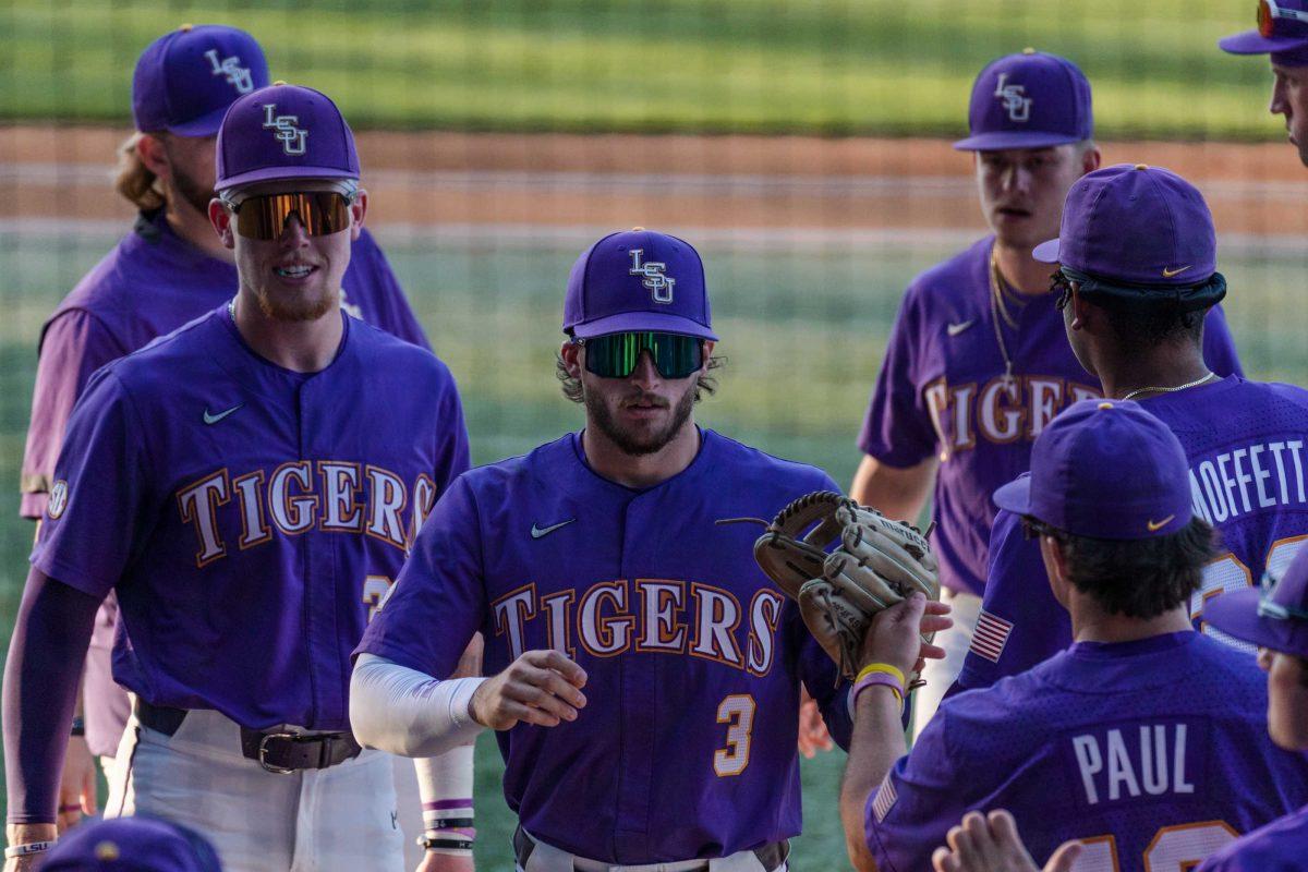 The LSU baseball team high-fives junior outfielder Dylan Crews (3) as he returns to the dugout on Friday, April 28, 2023, during LSU&#8217;s 8-6 win over Alabama at Alex Box Stadium in Baton Rouge, La.