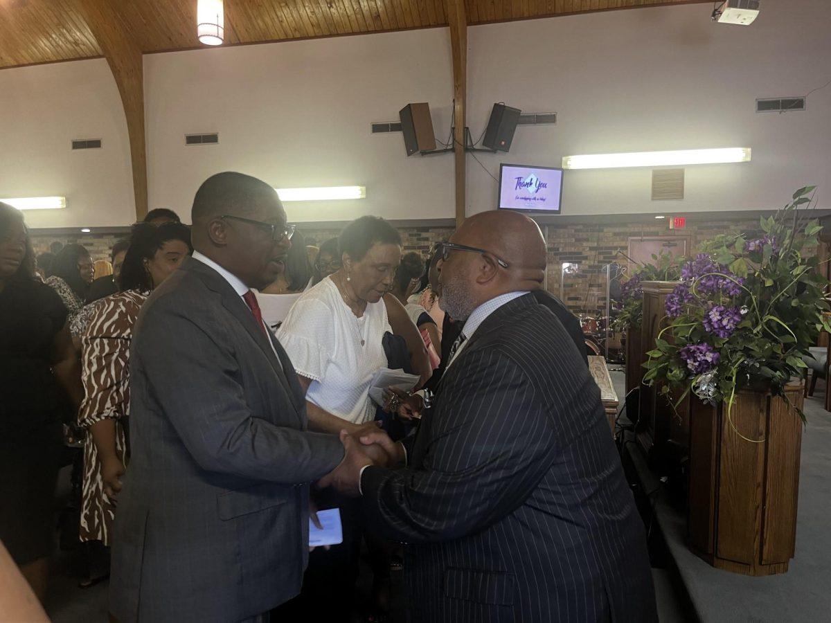 Democrat Shawn Wilson shakes hands with Rev. Leo D. Cyrus of New Hope Baptist Church after a service.