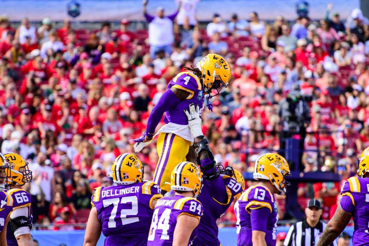 LSU football sophomore linebacker Harold Perkins Jr. (4) is lifted into the air following a touchdown on Monday, Jan. 1, 2024, during LSU's 35-31 victory against Wisconsin in Raymond James Stadium in Tampa, Fl.