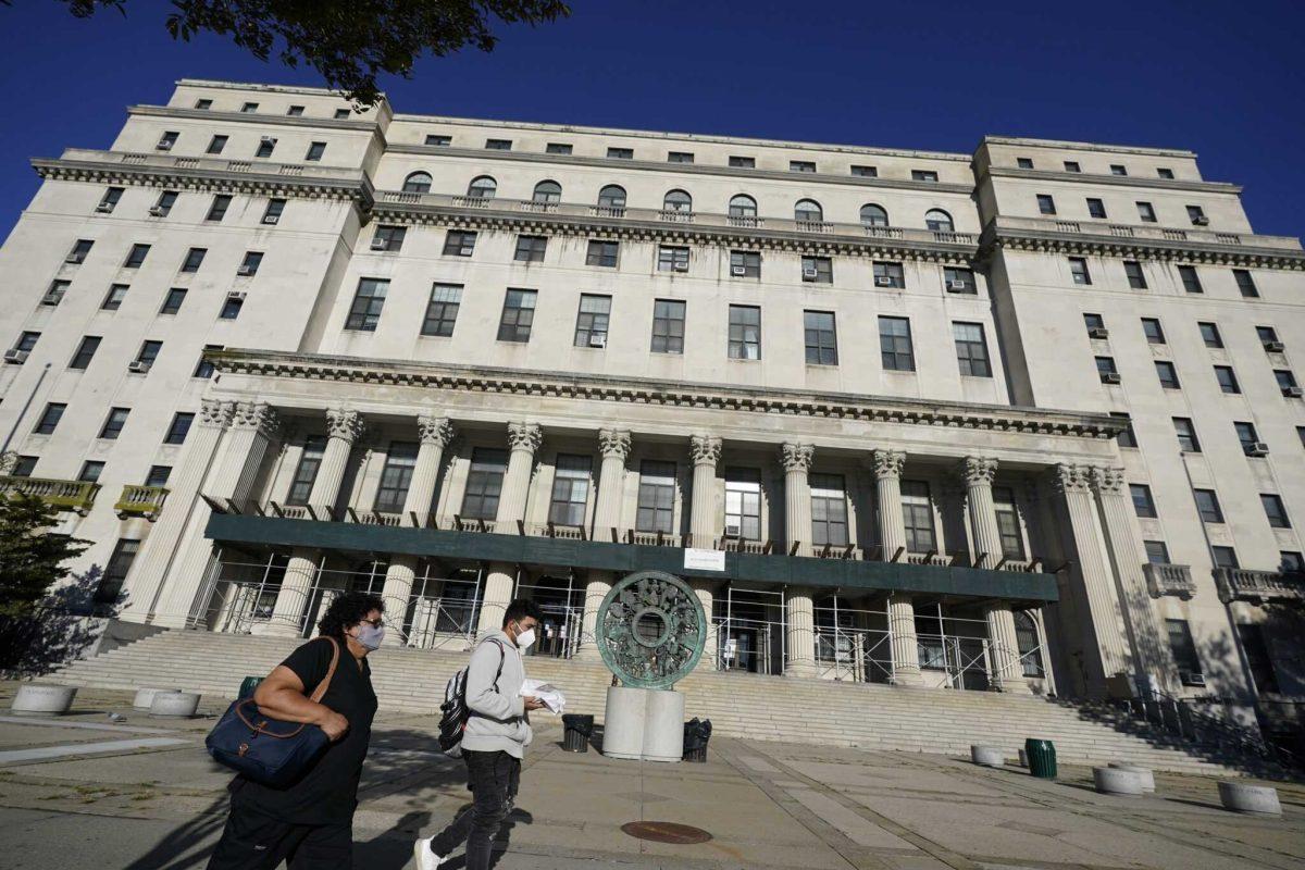 Pedestrians pass the Queens County Supreme Court Thursday, Oct. 8, 2020, in New York. (AP Photo/Frank Franklin II)