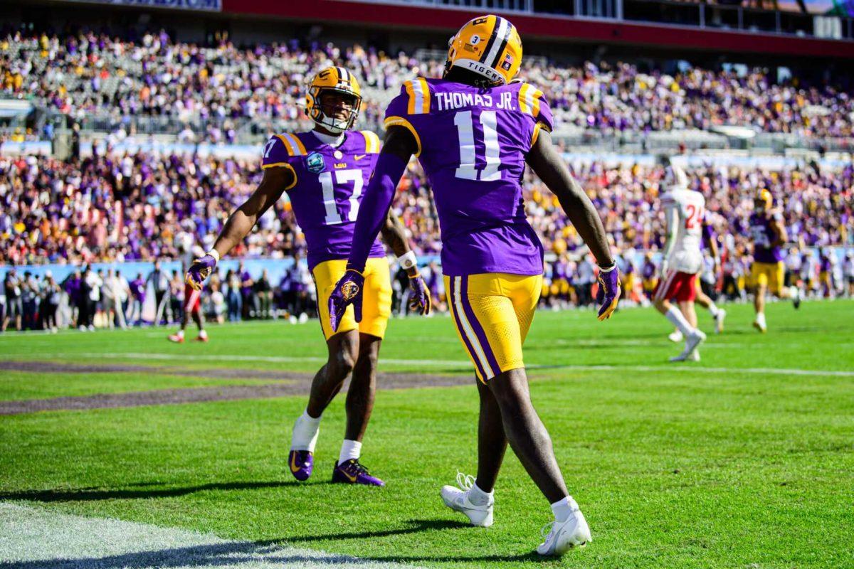 LSU football junior wide receiver Brian Thomas Jr. (11) celebrates a touchdown with LSU football redshirt sophomore wide receiver Chris Hilton Jr. (17) on Monday, Jan. 1, 2024, during LSU's 35-31 victory against Wisconsin in Raymond James Stadium in Tampa, Fl.