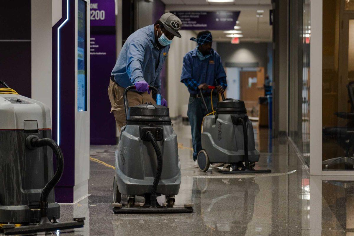 Maintenance workers vacuum up water Wednesday, Jan. 17, 2024, inside Patrick F. Taylor Hall on LSU's campus in Baton Rouge, La.