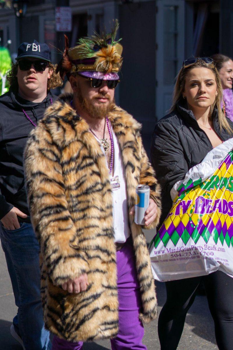 A man in a fur coat walks Tuesday, Feb. 13, 2024, on Bourbon Street in New Orleans, La.