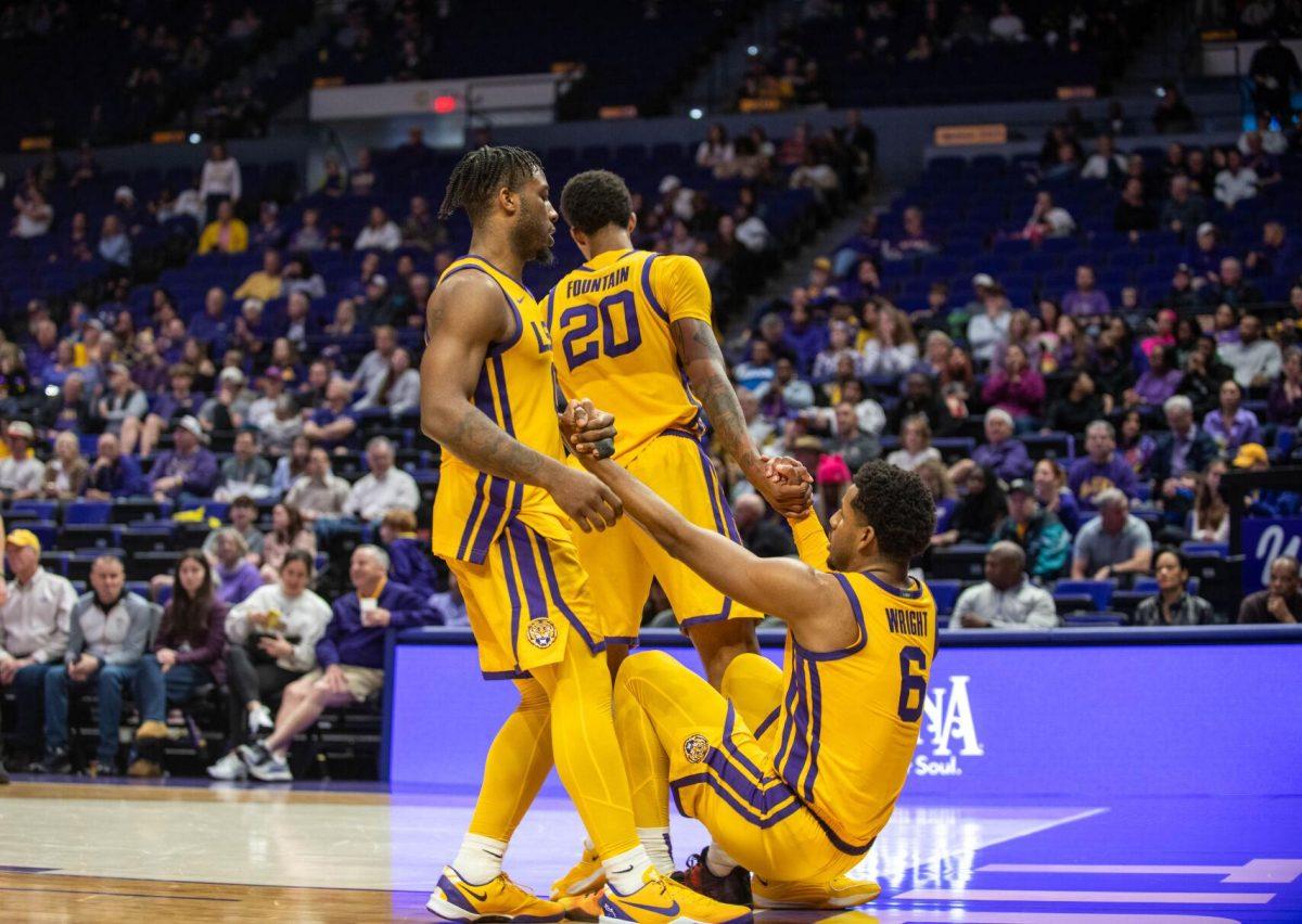 LSU men's Basketball senior forward Derek Fountain (20) and 5th-year senior guard Trae Hannibal (0) helps graduate student guard Jordan Wright (6) up on Saturday, Feb. 3, 2024, during LSU's 94-74 win against Arkansas in the Pete Maravich Assembly Center in Baton Rouge, La.