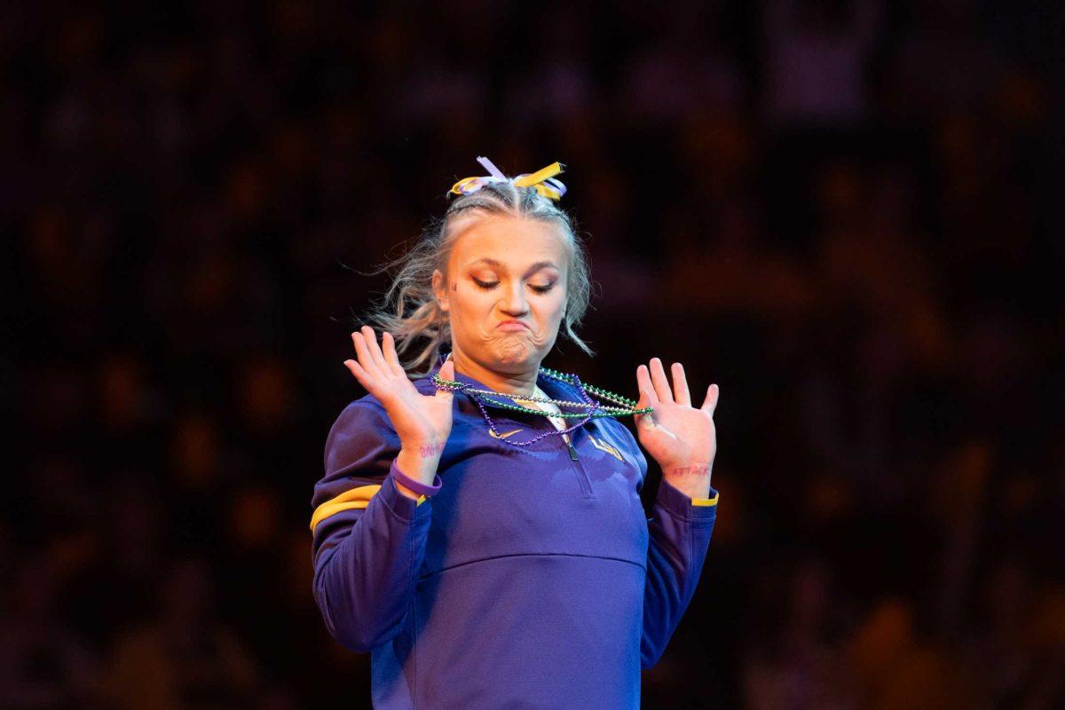 LSU gymnastics vault/balance beam/floor exercise graduate student Sierra Ballard sports Mardi Gras beads Friday, Feb. 2, 2024, before LSU&#8217;s 198.475-196.200 win against Arkansas at the Pete Maravich Assembly Center in Baton Rouge, La.