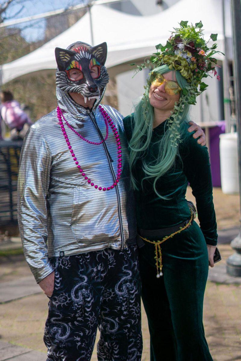 A wolf man and plant woman smile Tuesday, Feb. 13, 2024, on Bourbon Street in New Orleans, La.