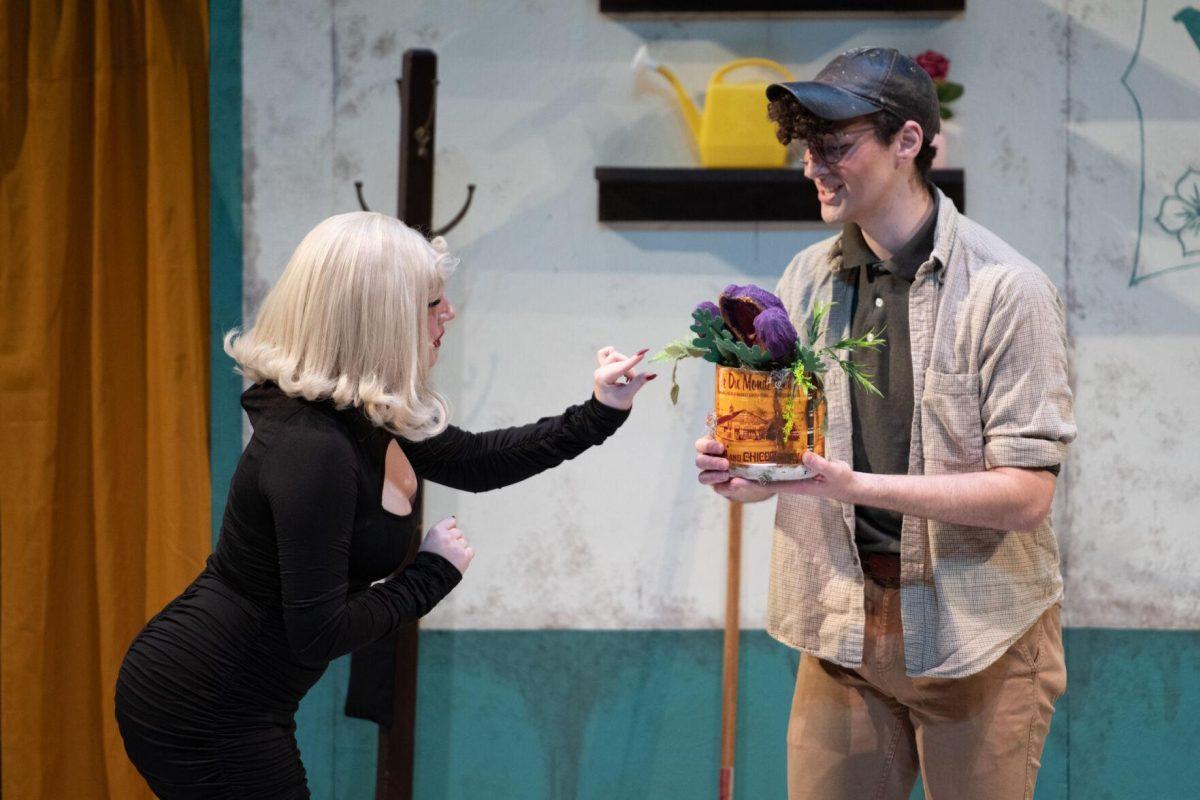 LSU psychology junior Thomas Becnel holds Audrenn II as theatre technology and design freshman Kamryn Hecker touches it Thursday, Feb. 1, 2024, during LSU Musical Theatre Club's performance of "Little Shop of Horrors" at the Reilly Theatre in Baton Rouge, La.