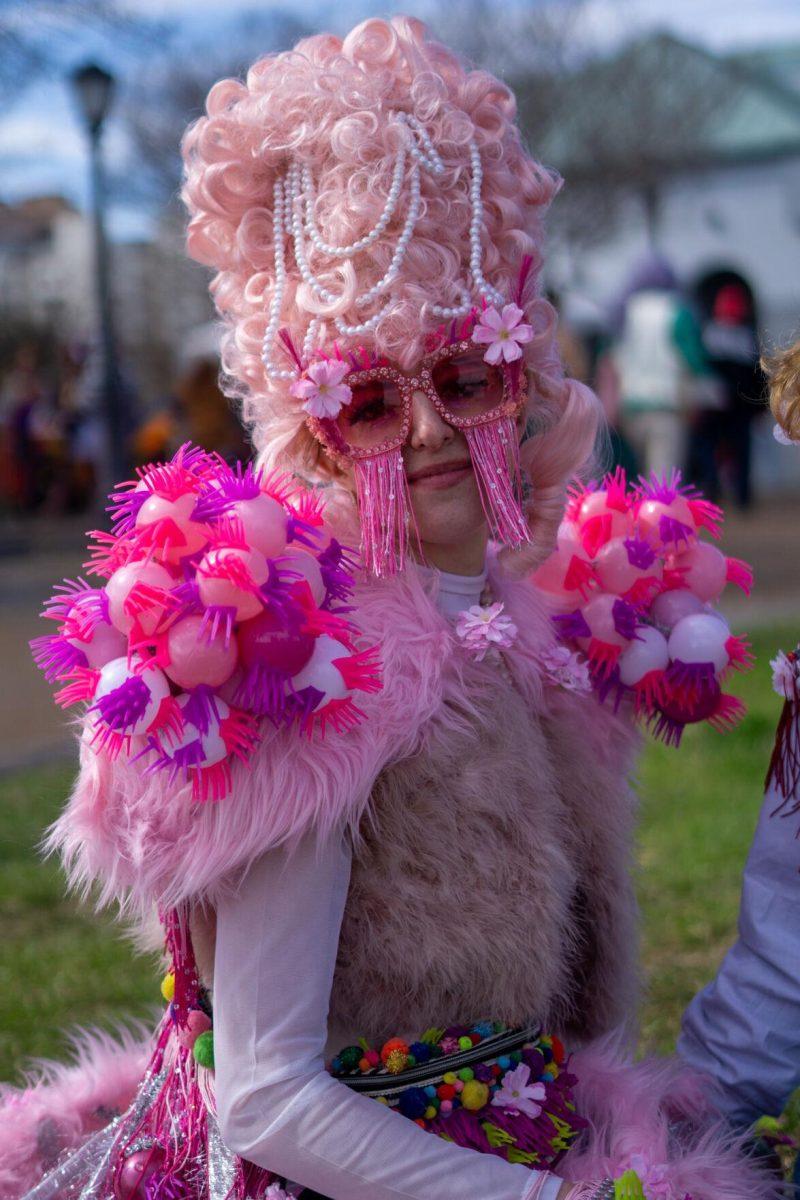 A woman in pink sits Tuesday, Feb. 13, 2024, at the Riverwalk in New Orleans, La.