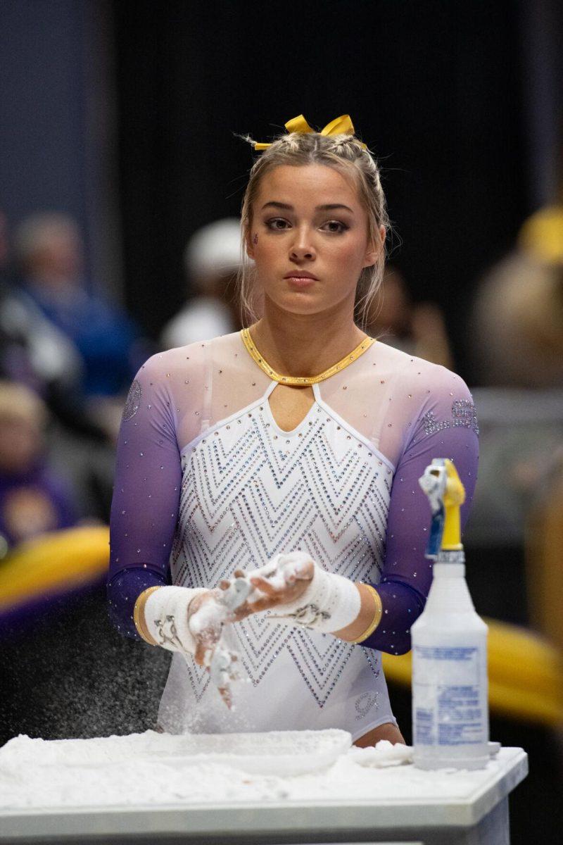 LSU gymnastics all-around senior Olivia Dunne chalks her hands Friday, Feb. 2, 2024, during LSU&#8217;s 198.475-196.200 win against Arkansas at the Pete Maravich Assembly Center in Baton Rouge, La.