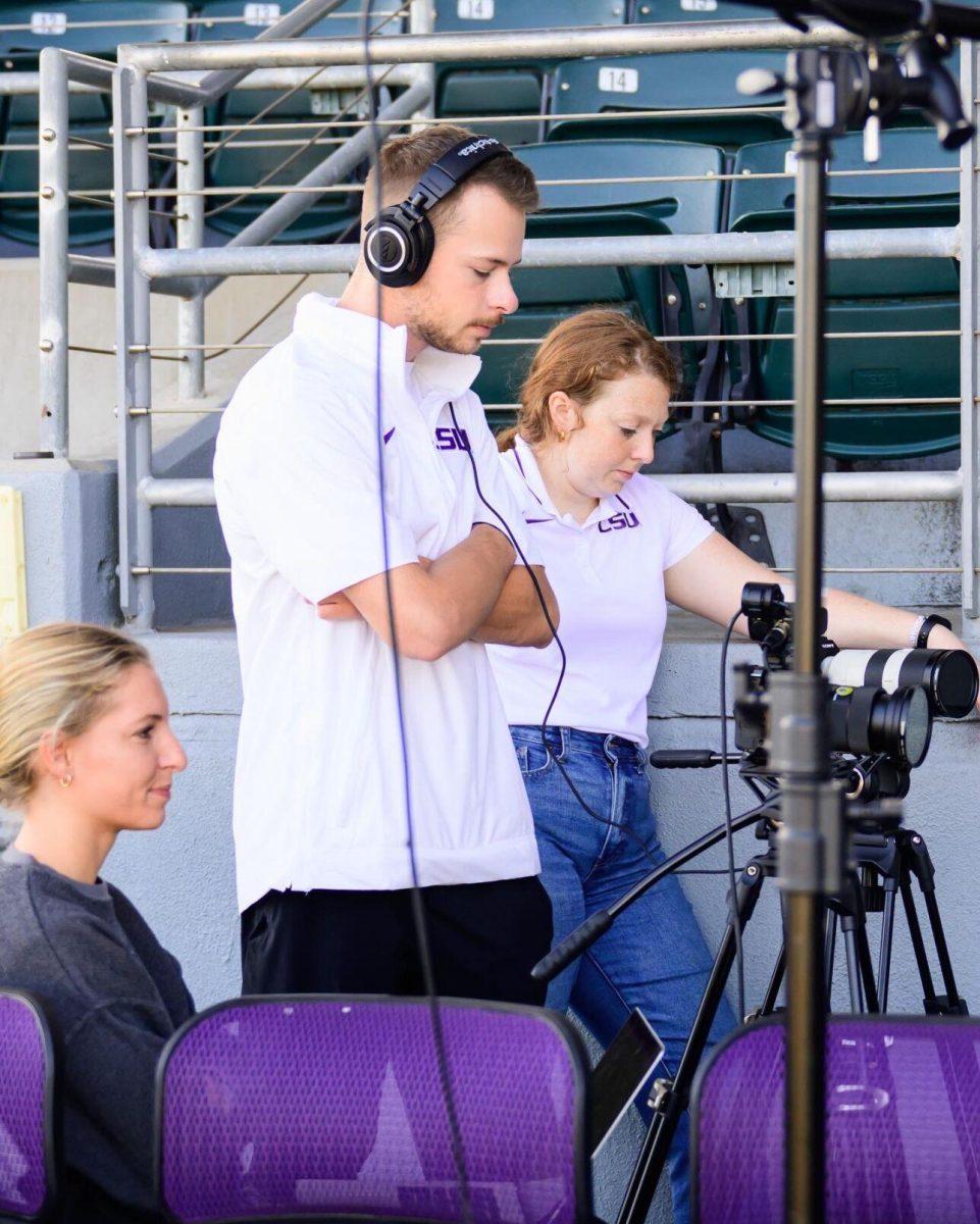 Dawson Ahrenstorff stands behind a camera while conducting interviews at Alex Box Stadium.&#160;