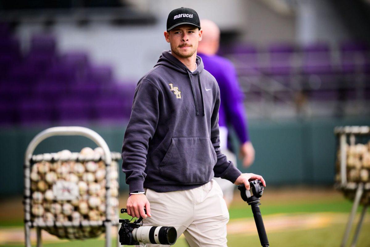 South Stadium Productions Creative Producer Dawson Ahrenstorff carries field equipment across LSU's Alex Box Stadium, Skip Bertman Field in Baton Rouge, La.&#160;