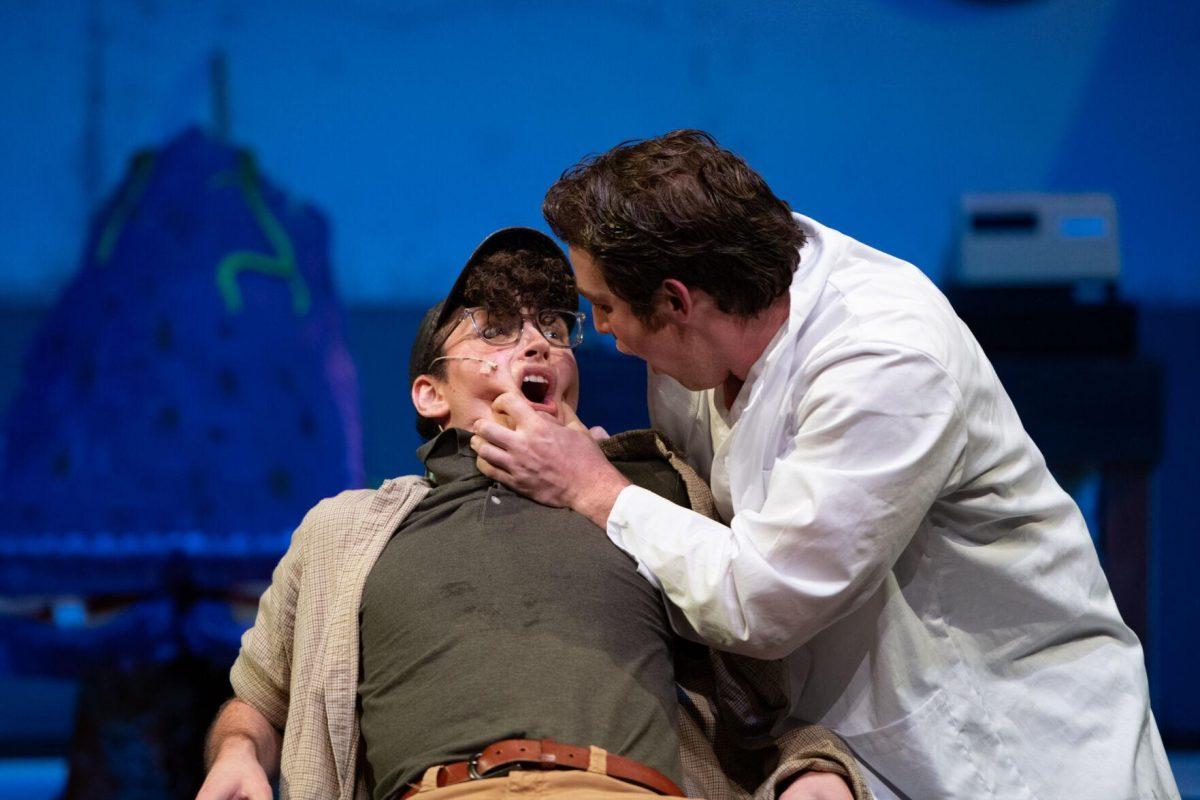 LSU theatre performance sophomore Don Fields opens psychology junior Thomas Becnel's mouth Thursday, Feb. 1, 2024, during LSU Musical Theatre Club's performance of "Little Shop of Horrors" at the Reilly Theatre in Baton Rouge, La.