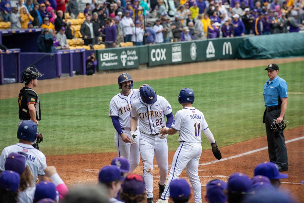 LSU baseball graduate student catcher Hayden Travinski (8), sophomore first basemen Jared Jones (22) and junior infielder Josh Pearson (11) celebrate Jones's homerun during LSU's 11-8 win against VMI on Friday, Feb. 16, 2024, at Alex Box Stadium in Baton Rouge, La.