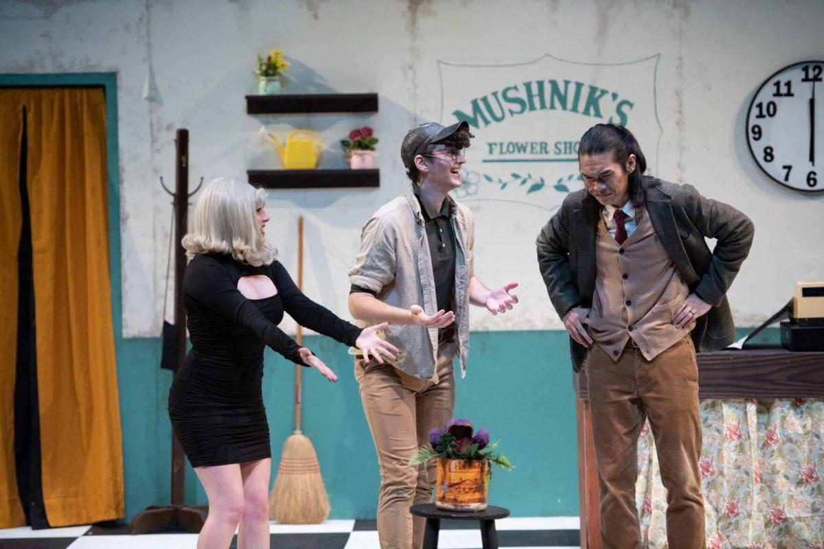 LSU theatre technology and design freshman Kamryn Hecker and psychology junior Thomas Becnel present Audrey II to vocal performance graduate student Mickey Zhang Thursday, Feb. 1, 2024, during LSU Musical Theatre Club's performance of "Little Shop of Horrors" at the Reilly Theatre in Baton Rouge, La.