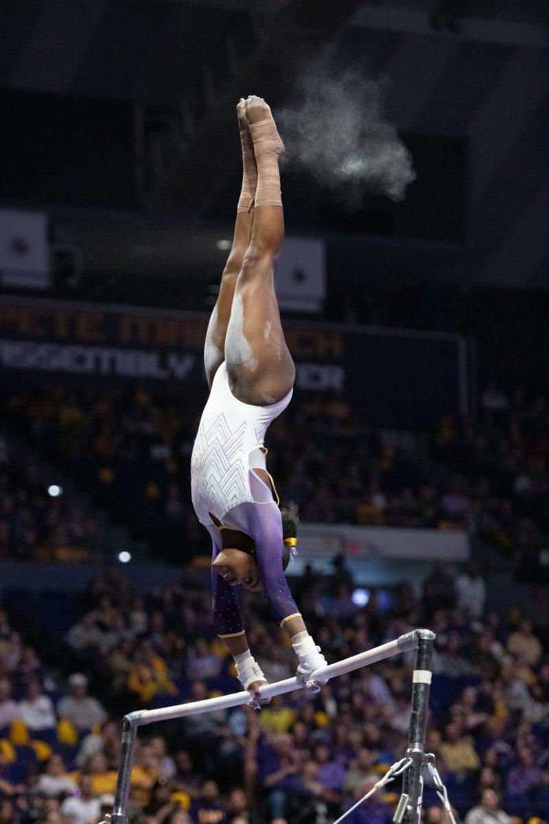 LSU gymnastics all-around graduate student Kiya Johnson swings from the uneven bars Friday, Feb. 2, 2024, during LSU&#8217;s 198.475-196.200 win against Arkansas at the Pete Maravich Assembly Center in Baton Rouge, La.