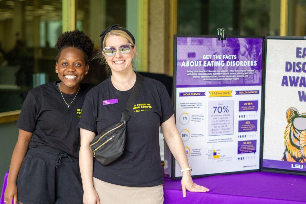 Emily Caire and her volunteer smile Wednesday, Feb. 28, 2024, in front of the LSU Library in Baton Rouge, La.