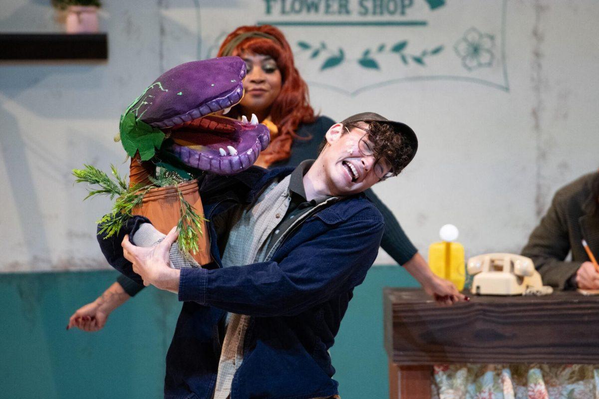 LSU psychology junior Thomas Becnel leans away from Audrey II Thursday, Feb. 1, 2024, during LSU Musical Theatre Club's performance of "Little Shop of Horrors" at the Reilly Theatre in Baton Rouge, La.