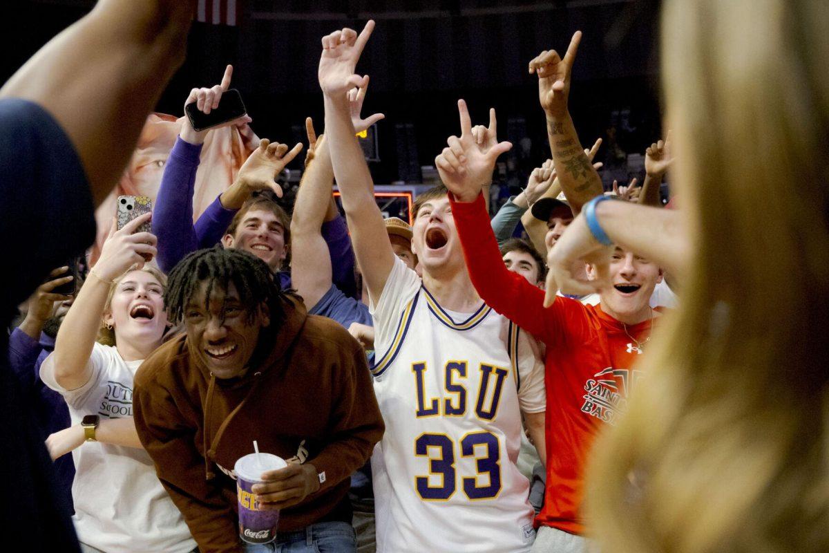 LSU students celebrate on the court after LSU defeated Kentucky in an NCAA college basketball game in Baton Rouge, La., Wednesday, Feb. 21, 2024. (AP Photo/Matthew Hinton)