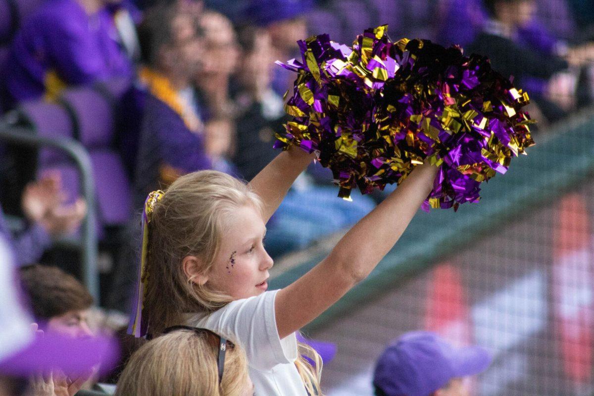 A young fan shakes her pom poms in cheer for the LSU baseball team during LSU's 11-8 win against VMI on Friday, Feb. 16, 2024, at Alex Box Stadium in Baton Rouge, La.