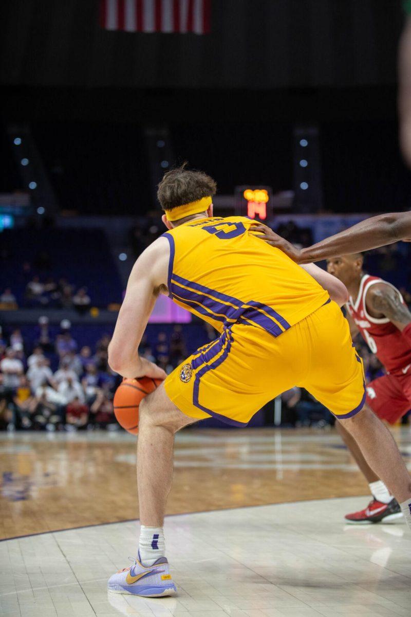 LSU men's basketball graduate student forward Will Baker (9) dodges an Arkansas player while dribbling the ball on Saturday, Feb. 3, 2024, during LSU's 94-74 win against Arkansas in the Pete Maravich Assembly Center in Baton Rouge, La.