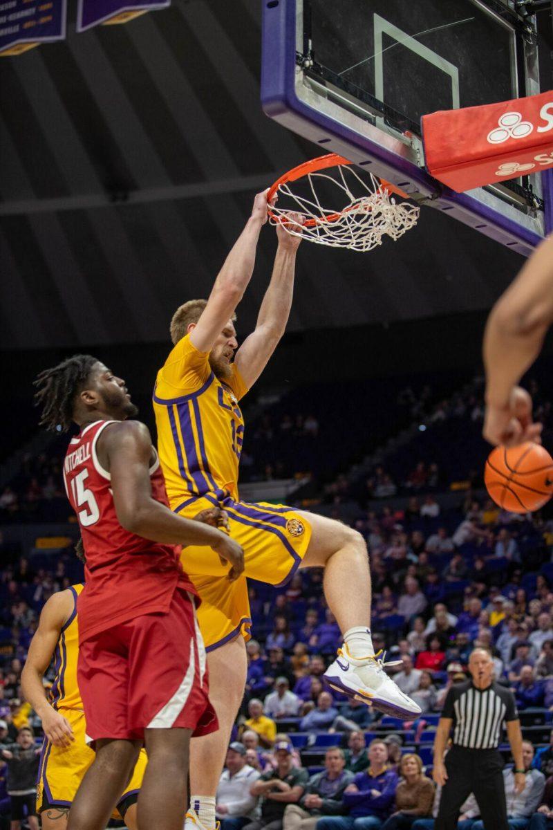 LSU men's basketball graduate student forward Hunter Dean (12) jumps and dunks the ball on Saturday, Feb. 3, 2024, during LSU's 94-74 win against Arkansas in the Pete Maravich Assembly Center in Baton Rouge, La.