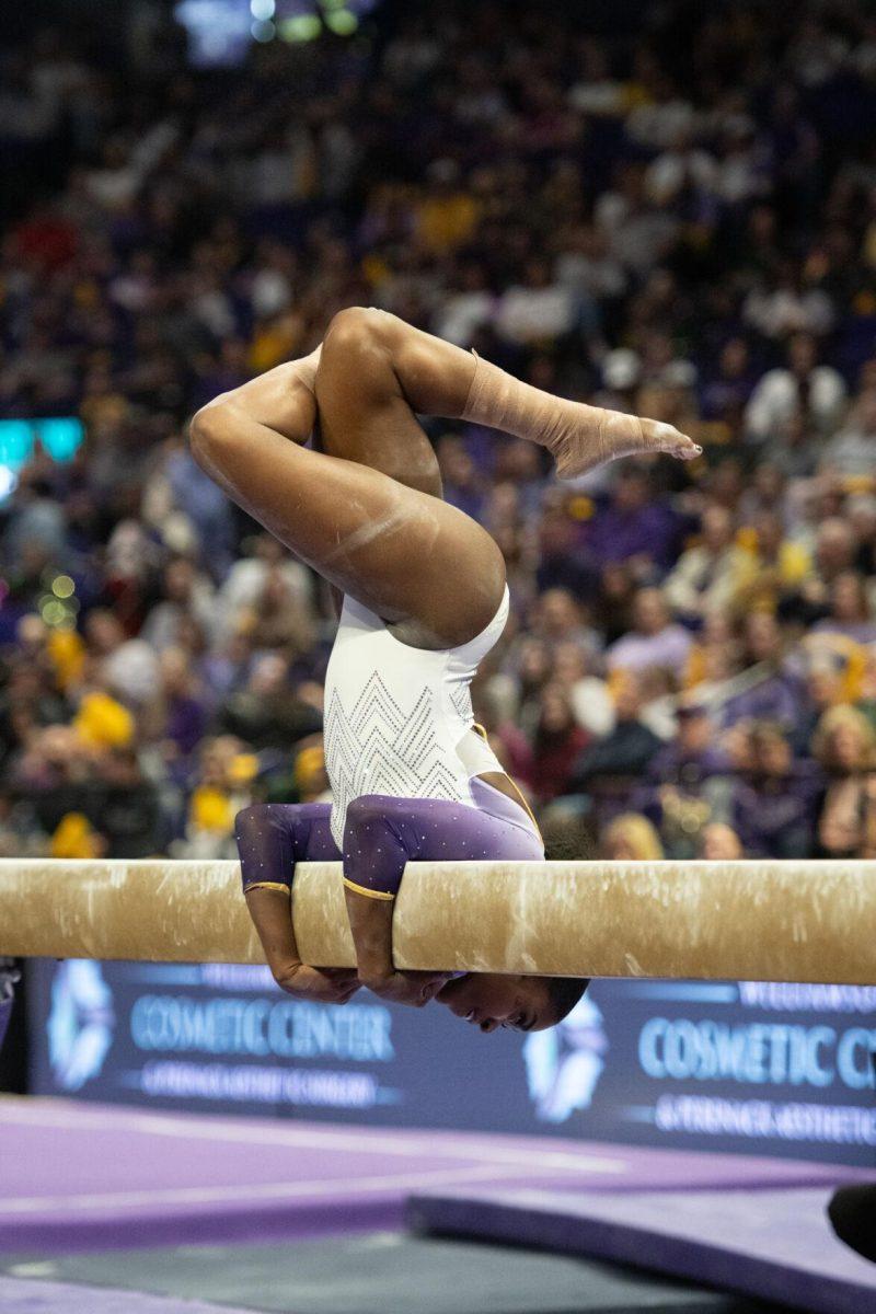 LSU gymnastics all-around graduate student Kiya Johnson hugs the balance beam Friday, Feb. 2, 2024, during LSU&#8217;s 198.475-196.200 win against Arkansas at the Pete Maravich Assembly Center in Baton Rouge, La.