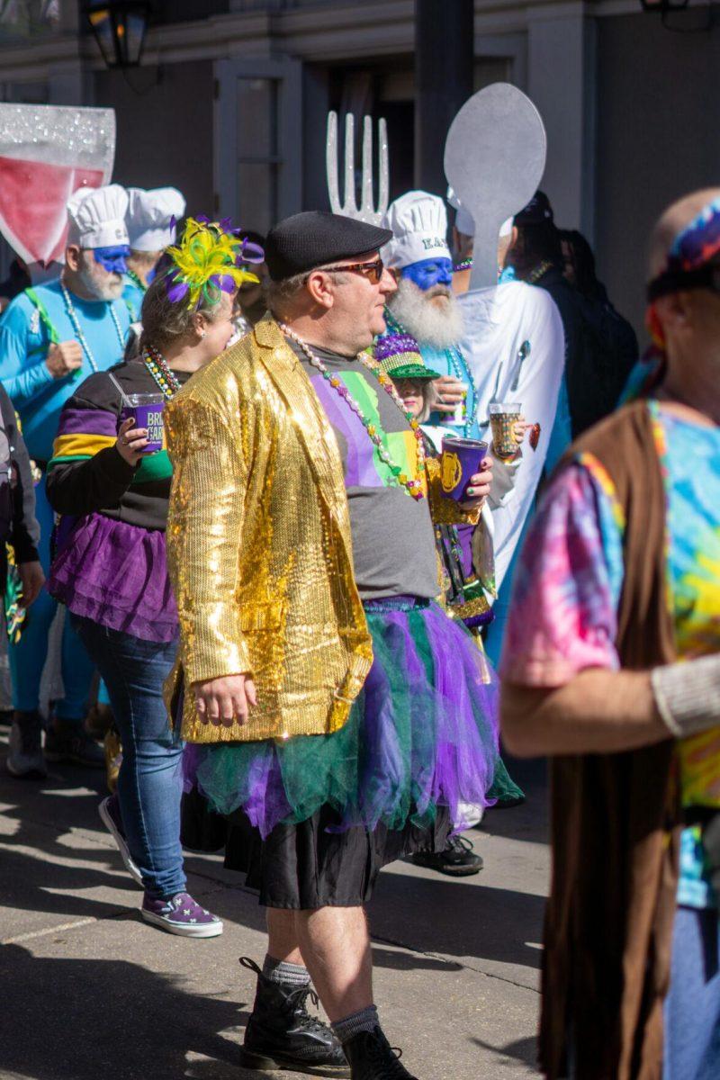 A man in a skirt and blazer walks Tuesday, Feb. 13, 2024, on Bourbon Street in New Orleans, La.