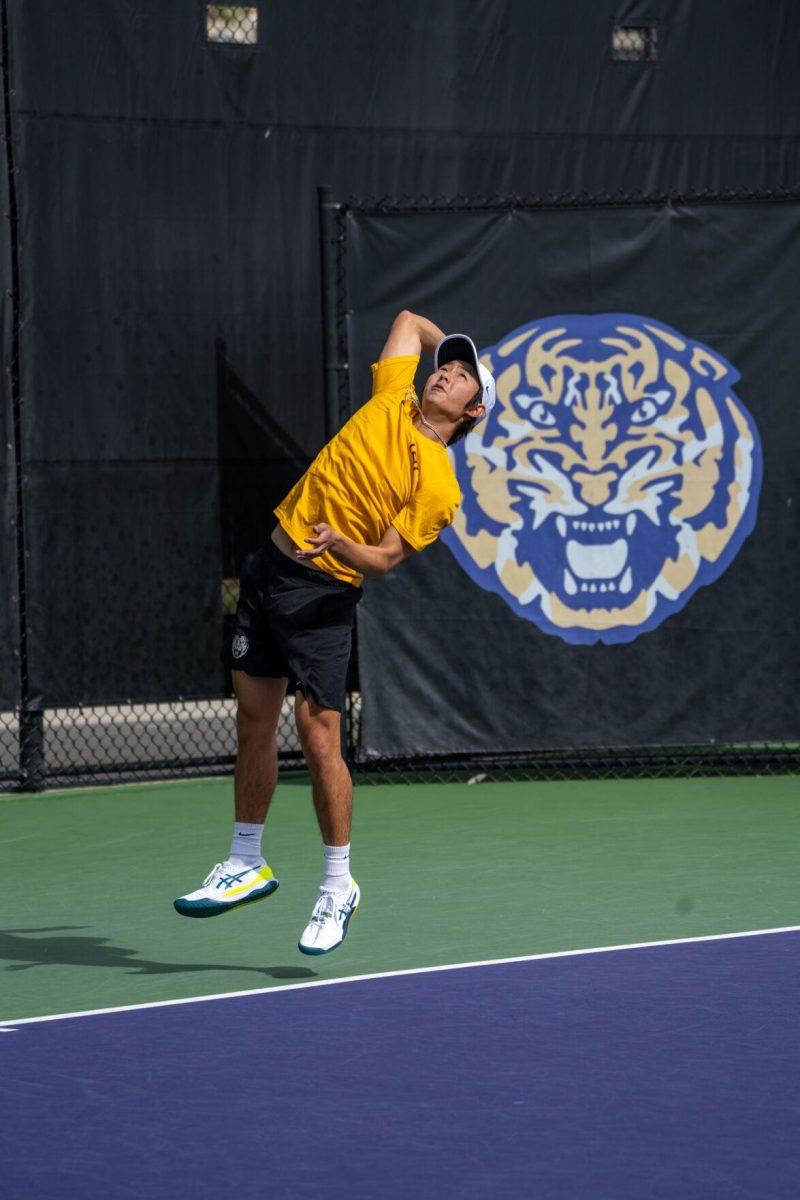 LSU men's tennis senior Chen Dong hits a serve during his 5-7, 6-3, 6-2 singles win against Rice on Sunday, Feb. 4, 2023 at the LSU Tennis Complex on Gourrier Avenue in Baton Rouge, La.