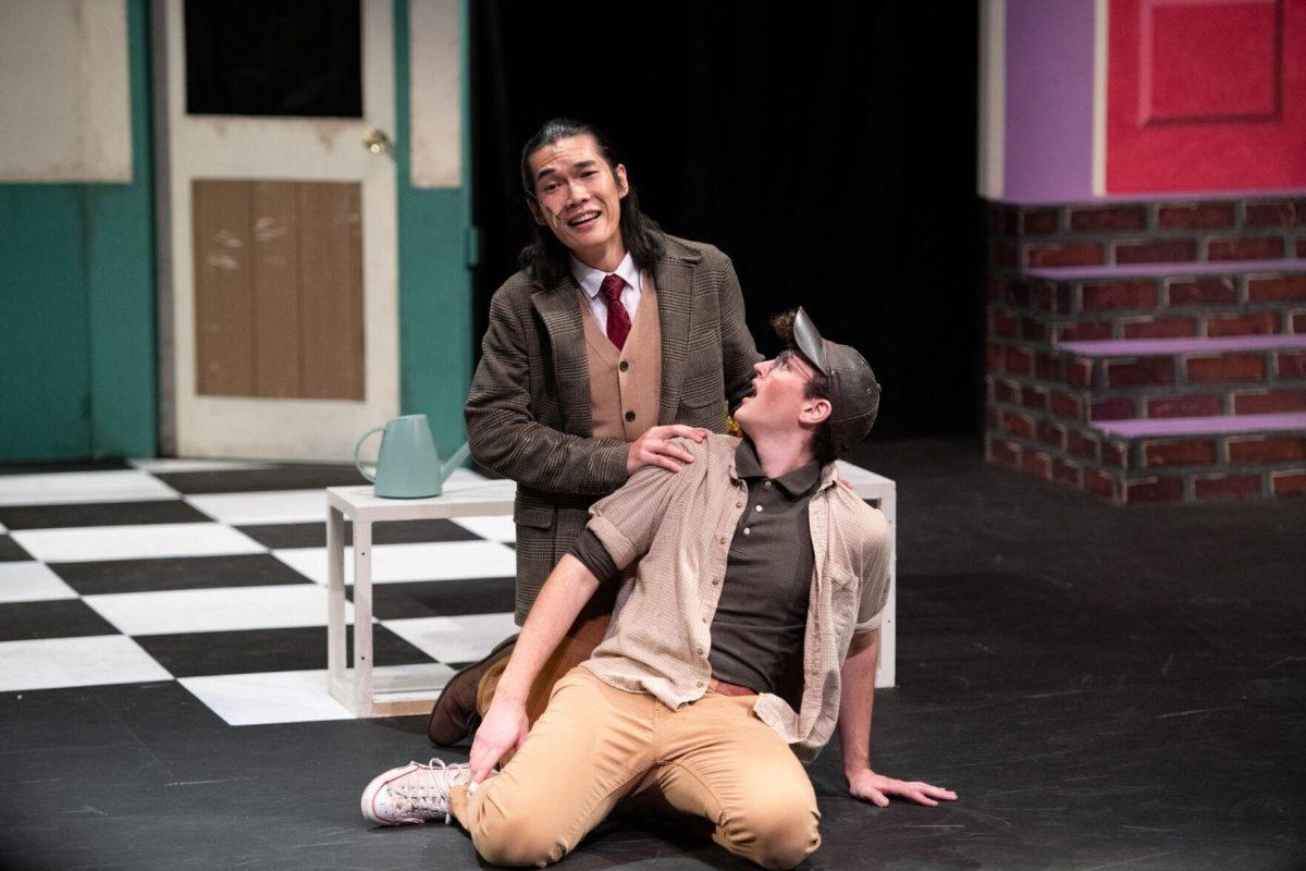 LSU vocal performance graduate student Mickey Zhang kneels behind psychology junior Thomas Becnel Thursday, Feb. 1, 2024, during LSU Musical Theatre Club's performance of "Little Shop of Horrors" at the Reilly Theatre in Baton Rouge, La.