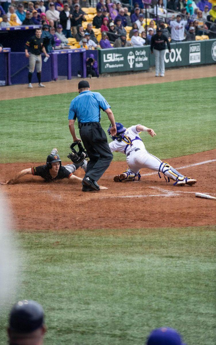 LSU baseball graduate student catcher Alex Milazzo (7) attempts to tag a VMI player out at home plate during LSU's 11-8 win against VMI on Friday, Feb. 16, 2024, at Alex Box Stadium in Baton Rouge, La.