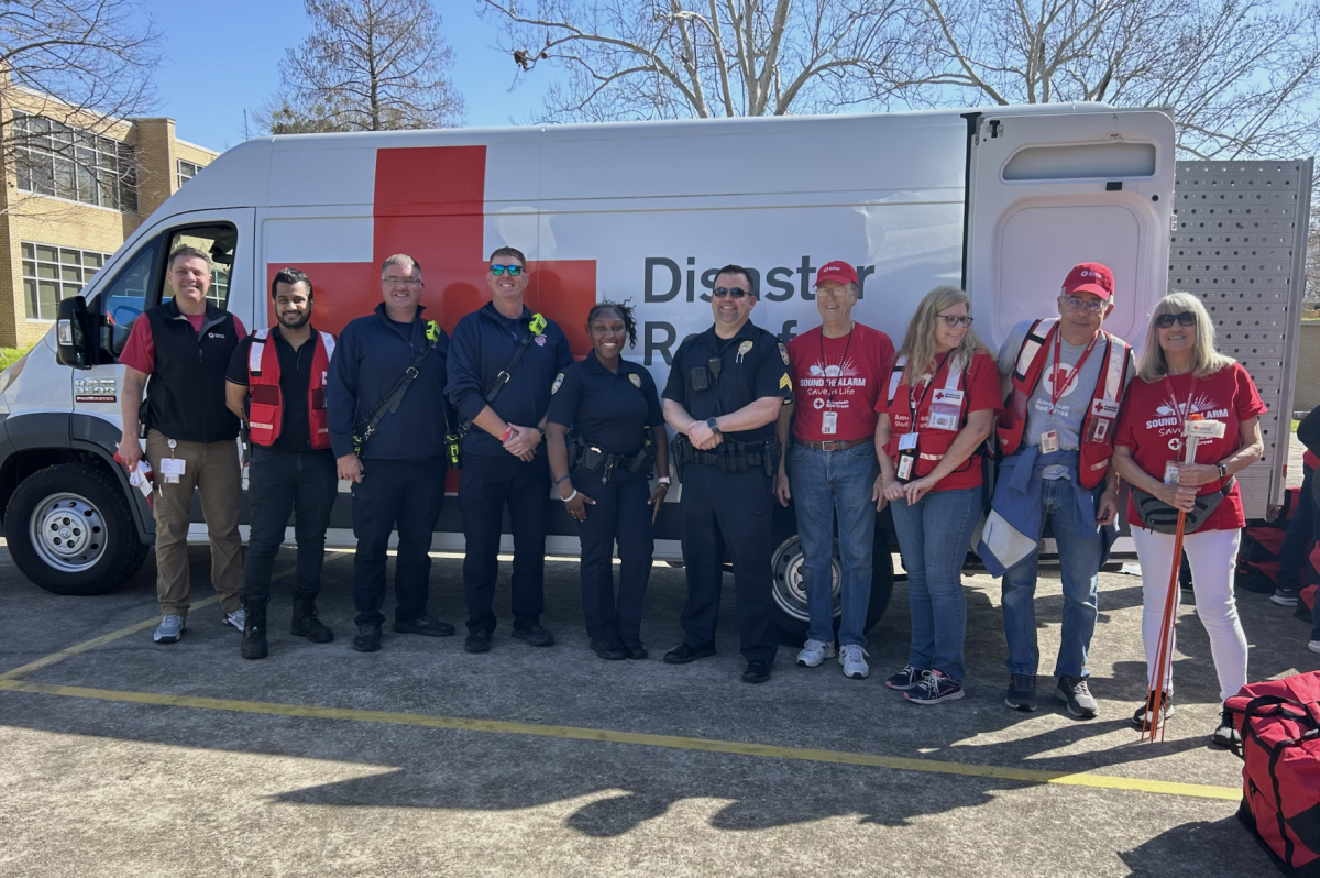 Red Cross organization leaders and Baton Rouge Police Department stand outside of a Red Cross van at "Sound the Alarm" event on Feb. 24, 2024