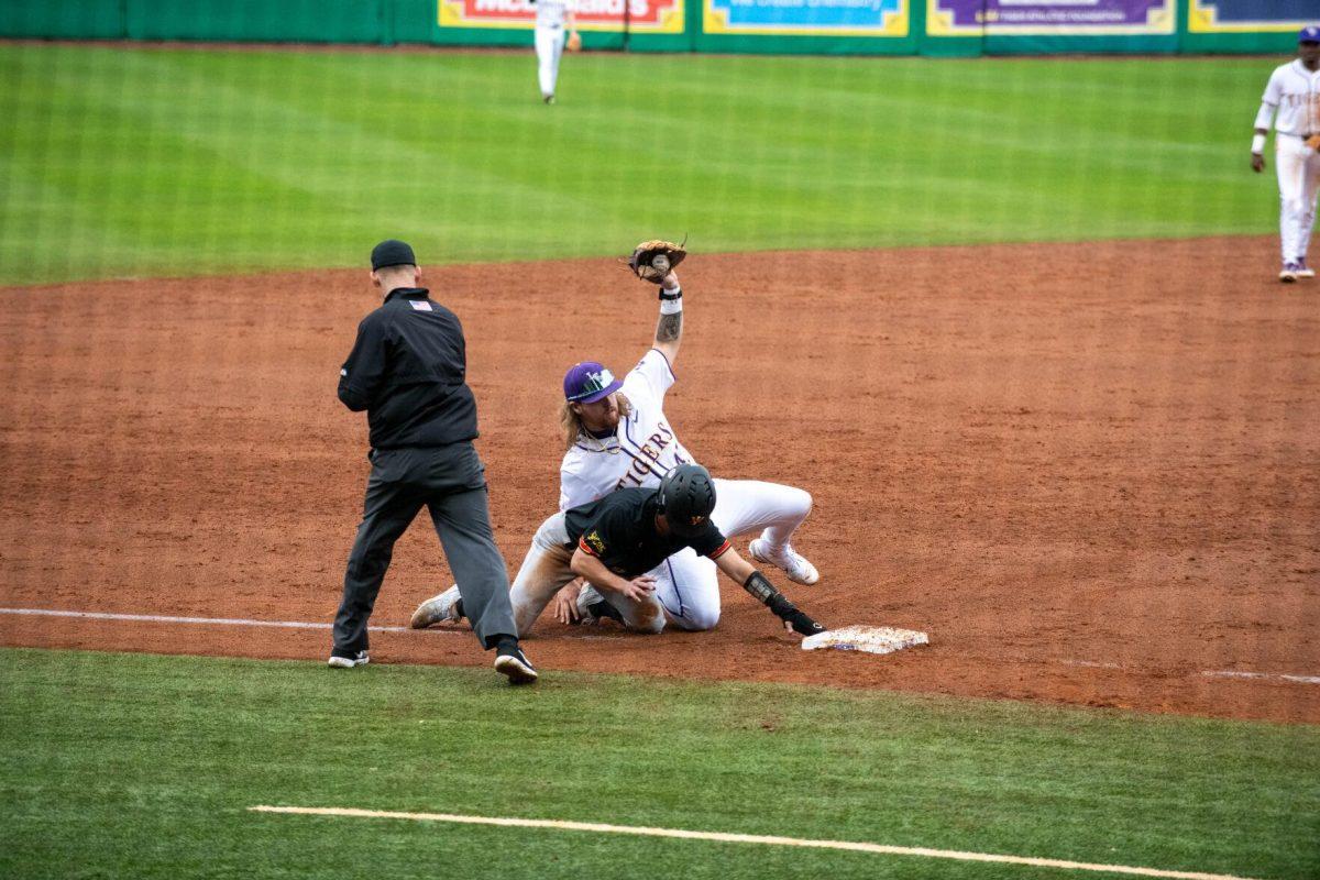 LSU baseball junior third baseman Tommy White (47) tags a VMI player out at third base during LSU's 11-8 win against VMI on Friday, Feb. 16, 2024, at Alex Box Stadium in Baton Rouge, La.