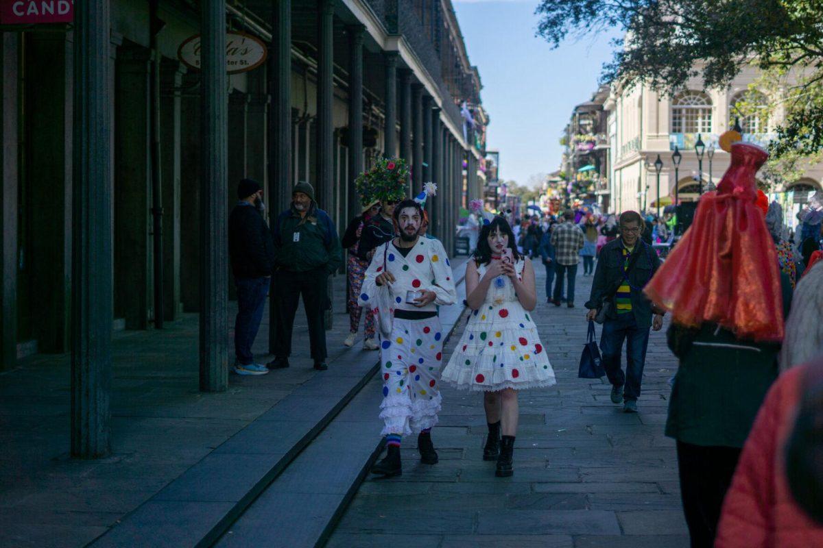 A couple dressed as polka dots walk Tuesday, Feb. 13, 2024, on Bourbon Street in New Orleans, La.