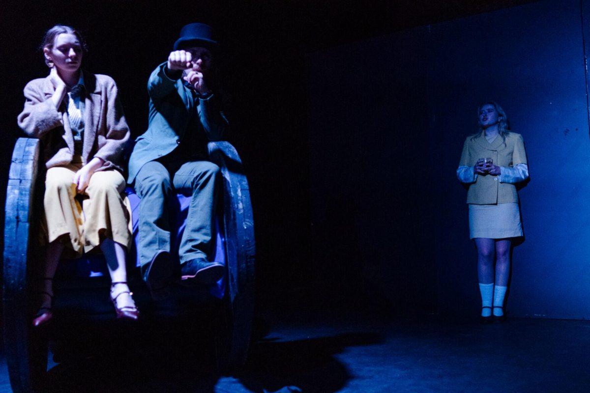 Older Nich Carraway (Sophie Rollins) speaks as younger Nick Carraway (Emily Pounds) and Tom Buchanan (Cameron Beall) ride in a car in a production of Yearning Sunday, March 3, 2024, in Coates Hall on LSU's campus.