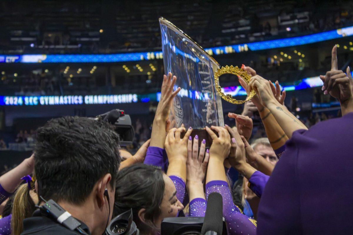 The LSU gymnastics team lifts the SEC Gymnastics trophy Saturday, March 23, 2024, following LSU's 198.075 victory in the 2024 SEC Gymnastics Championship in the Smoothie King Center in New Orleans, La.