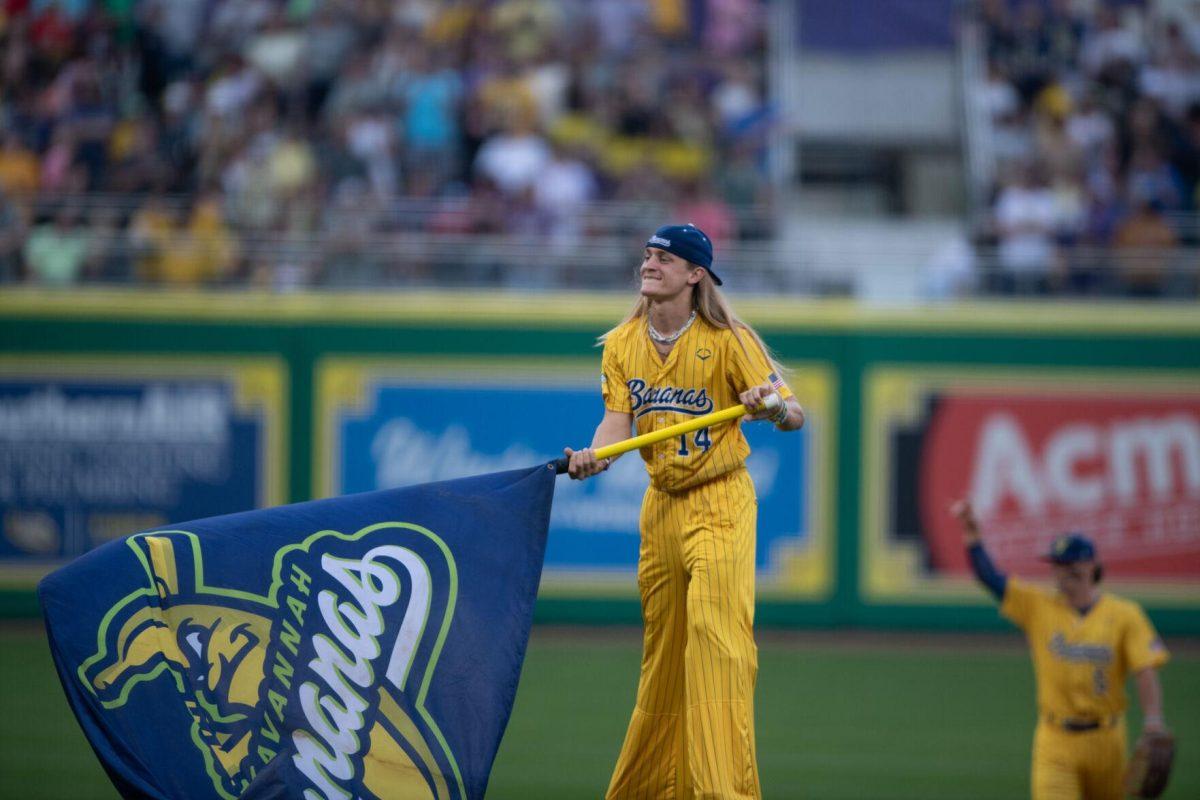 Savannah Bananas utility Dakota Albritton (14) waves a flag while on stilts Thursday, March 14, 2024, before the Savannah Bananas 5-4 loss to the Party Animals during their world tour stop at Alex Box Stadium in Baton Rouge, La.