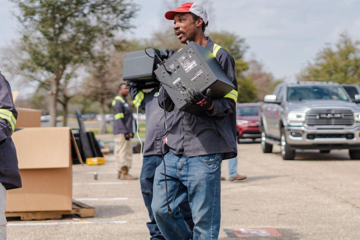 A worker carries electronic waste Saturday, March 2, 2024, at the Household Hazardous Materials Collection Day on LSU's campus in Baton Rouge, La.